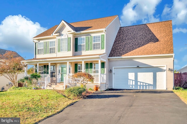 view of front of property with a porch, a front yard, and a garage