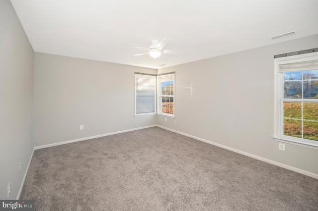 carpeted empty room featuring a wealth of natural light and ceiling fan