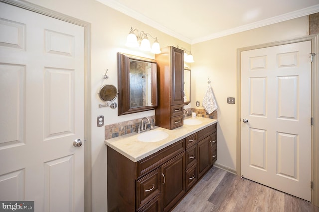 bathroom with hardwood / wood-style floors, vanity, decorative backsplash, and ornamental molding