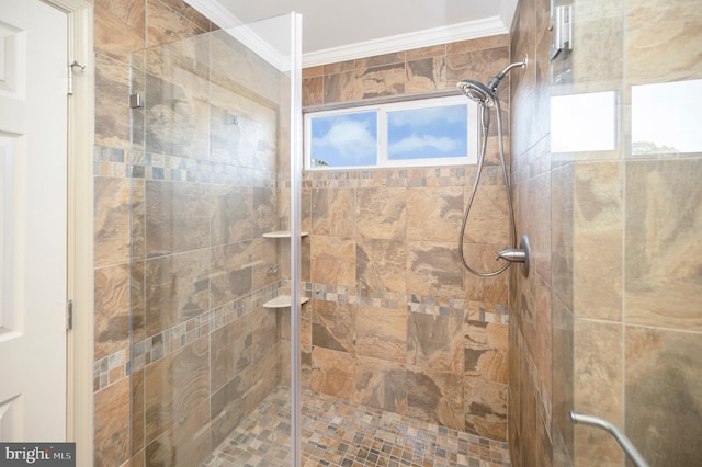 bathroom with a tile shower and crown molding