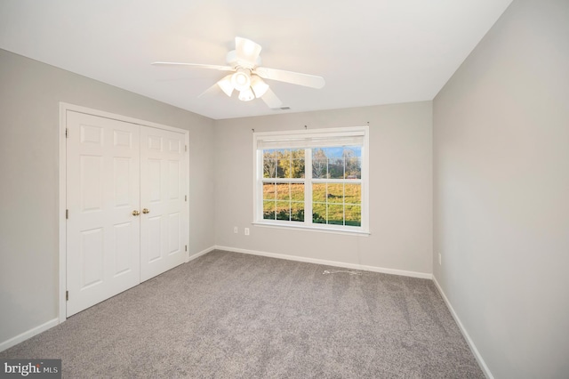 unfurnished bedroom with carpet flooring, ceiling fan, and a closet