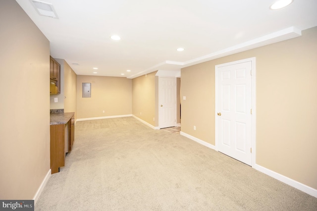 basement featuring electric panel and light carpet