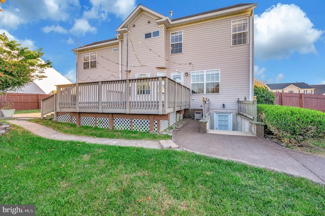 back of property featuring a deck and a yard