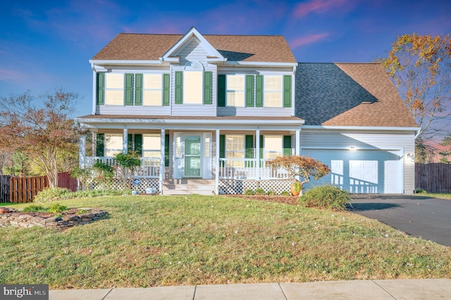 view of front of house with a garage, a lawn, and a porch