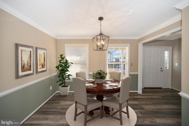 dining area with ornamental molding, an inviting chandelier, and dark hardwood / wood-style floors