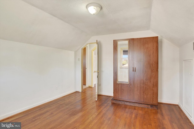 bonus room featuring dark hardwood / wood-style flooring and vaulted ceiling