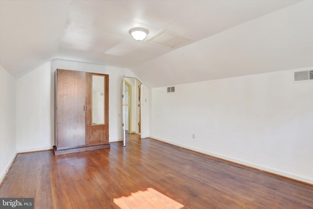 additional living space with dark hardwood / wood-style flooring and lofted ceiling