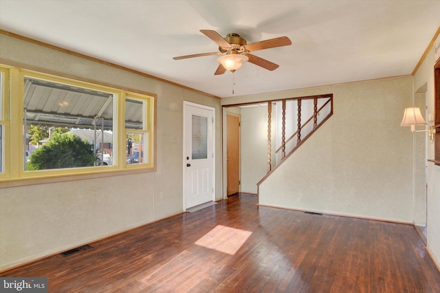 empty room featuring ceiling fan, dark hardwood / wood-style floors, and crown molding