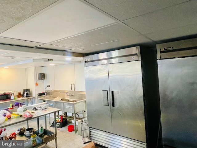 kitchen with a paneled ceiling and white cabinetry