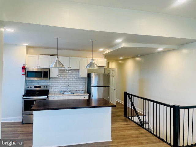 kitchen featuring a center island, white cabinets, wood-type flooring, and appliances with stainless steel finishes