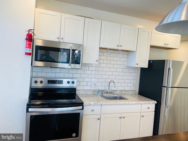 kitchen with backsplash, white cabinetry, sink, and appliances with stainless steel finishes