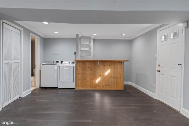 washroom with dark hardwood / wood-style flooring, crown molding, and washer and clothes dryer