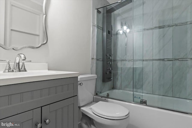 full bathroom featuring vanity, enclosed tub / shower combo, and toilet