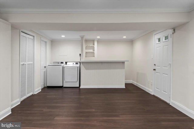 laundry room featuring ornamental molding, dark hardwood / wood-style flooring, washer and clothes dryer, and bar area