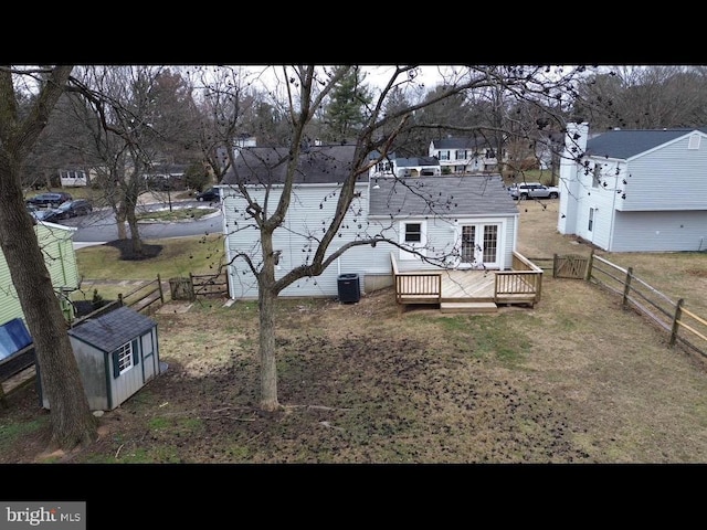 back of house with a wooden deck, central AC unit, and a storage shed