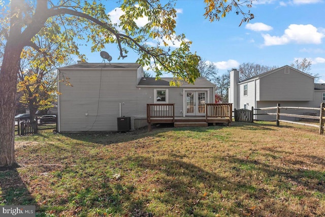 rear view of property with cooling unit, a wooden deck, a yard, and french doors