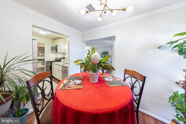 dining room featuring crown molding, dark wood-type flooring, and a notable chandelier