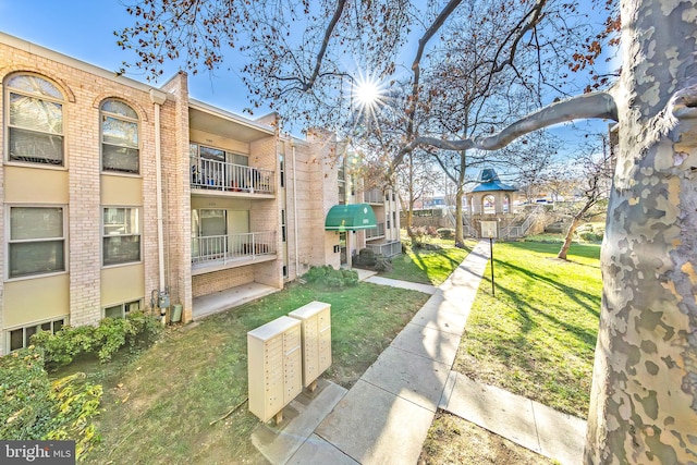 surrounding community featuring a lawn and mail boxes