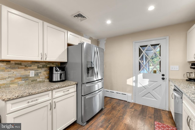 kitchen with white cabinetry, appliances with stainless steel finishes, light stone counters, and a baseboard heating unit