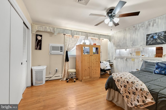 bedroom with a closet, a wall mounted AC, ceiling fan, and light hardwood / wood-style flooring