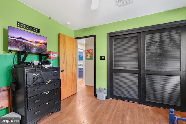 bedroom with light hardwood / wood-style floors and a closet