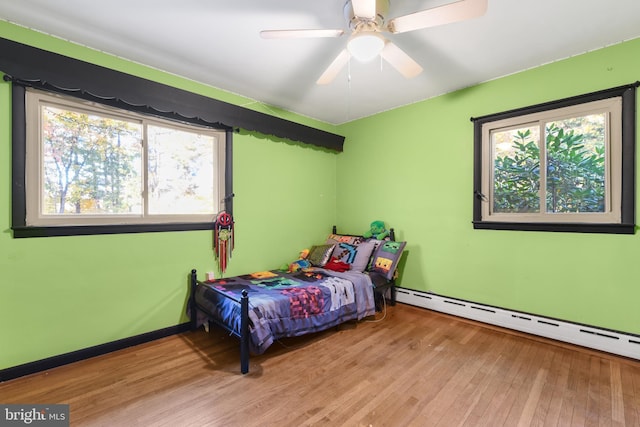 316 Spring Valley Rd, Reading, PA 19605 - bedroom featuring a baseboard heating unit, multiple windows, hardwood / wood-style flooring, and baseboards