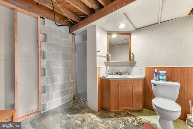 bathroom with vanity, concrete floors, toilet, and wood walls