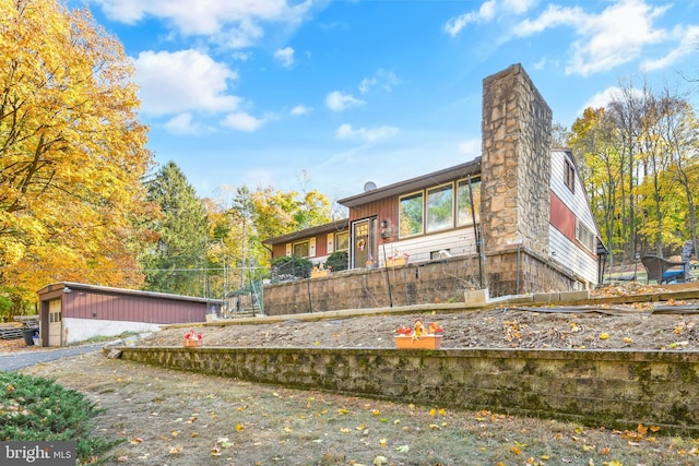 rear view of house with an outdoor structure