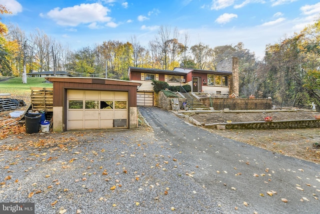 316 Spring Valley Rd, Reading, PA 19605 - view of front of house featuring a chimney, a detached garage, an outbuilding, and view of wooded area