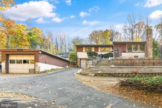 316 Spring Valley Rd, Reading, PA 19605 - view of front of house with stairway, a chimney, a detached garage, and an outbuilding