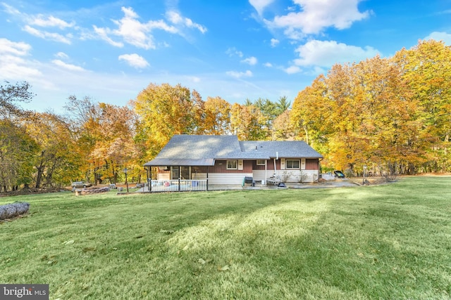 rear view of property featuring a patio and a lawn