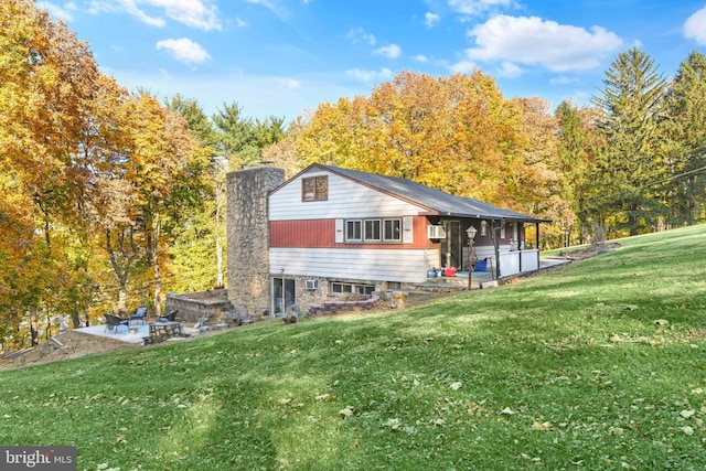 316 Spring Valley Rd, Reading, PA 19605 - rear view of house with a lawn, a patio, a chimney, and an AC wall unit