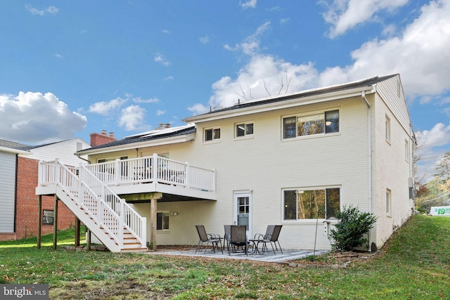 back of property featuring a lawn, a patio area, and a deck