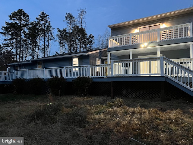 back house at dusk with a deck