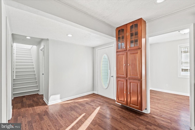 foyer entrance featuring a textured ceiling and dark hardwood / wood-style floors