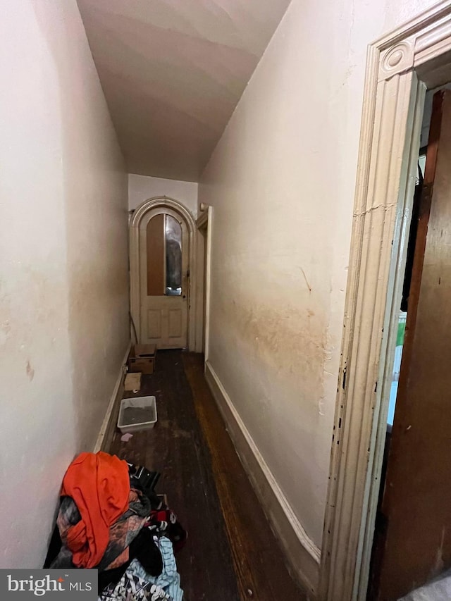 hallway with hardwood / wood-style floors and vaulted ceiling