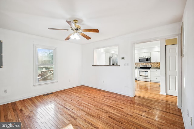 unfurnished living room featuring ceiling fan and light wood-type flooring