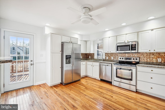 kitchen featuring light wood-type flooring, white cabinetry, and stainless steel appliances