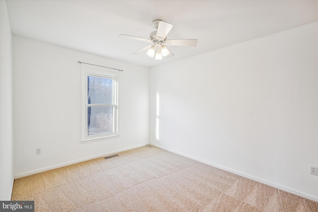 spare room with ceiling fan and light colored carpet