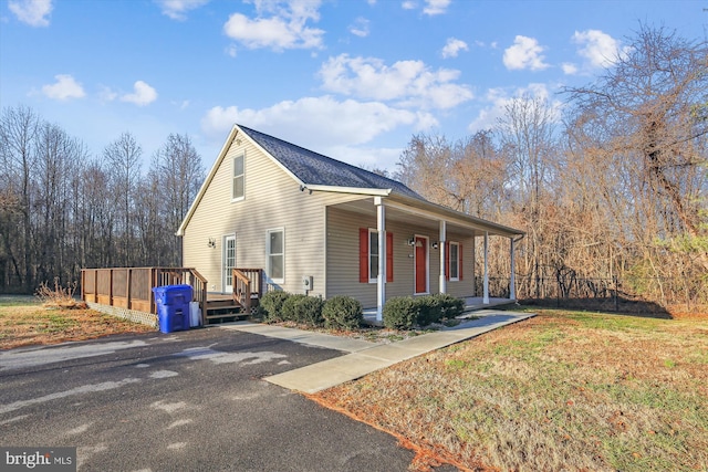 view of front of house featuring covered porch and a front lawn