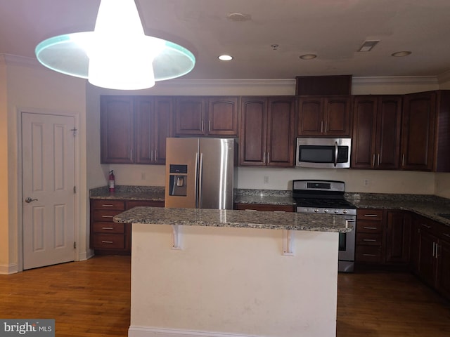 kitchen with stainless steel appliances, stone counters, a breakfast bar area, dark hardwood / wood-style floors, and a kitchen island