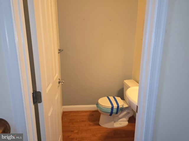 bathroom featuring wood-type flooring and toilet