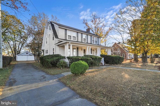 view of front of home with an outbuilding, covered porch, and a garage