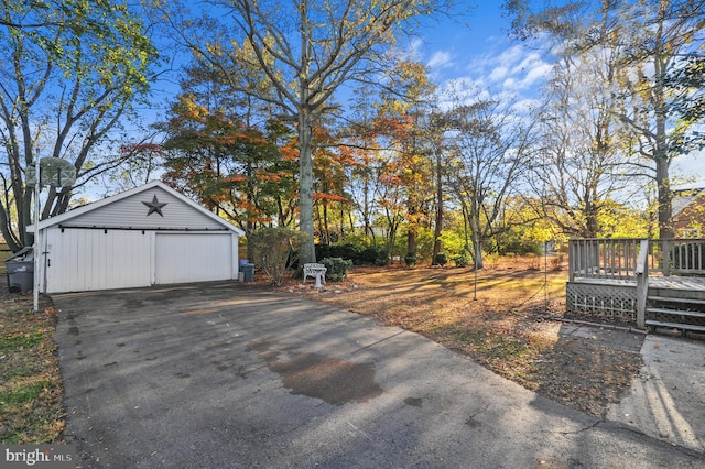 view of yard with a garage, an outdoor structure, and a wooden deck