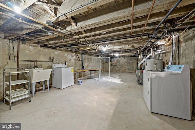 basement featuring gas water heater, separate washer and dryer, and sink