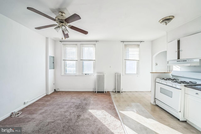 kitchen featuring white cabinetry, white range with gas stovetop, and radiator heating unit