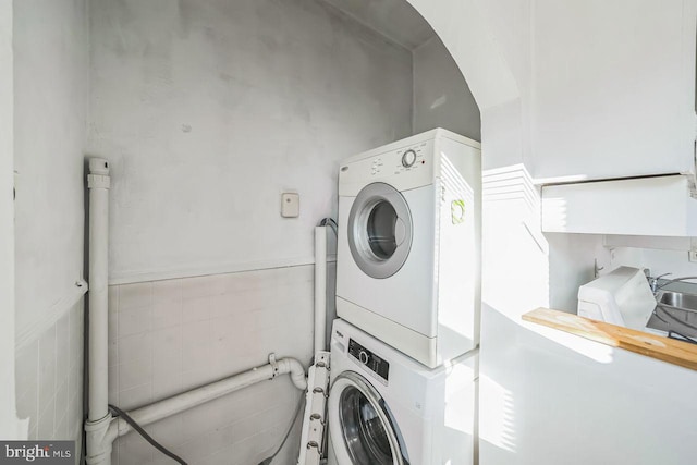 laundry area with stacked washer and dryer