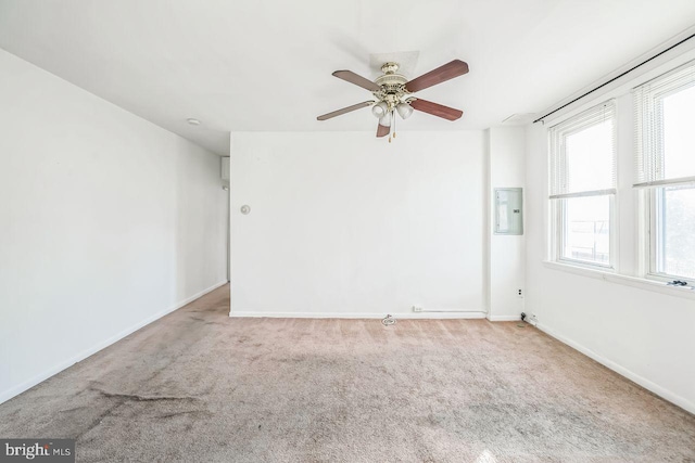 empty room with light carpet, electric panel, and ceiling fan