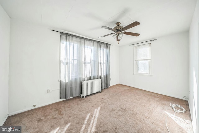 unfurnished room featuring ceiling fan, radiator heating unit, and light carpet