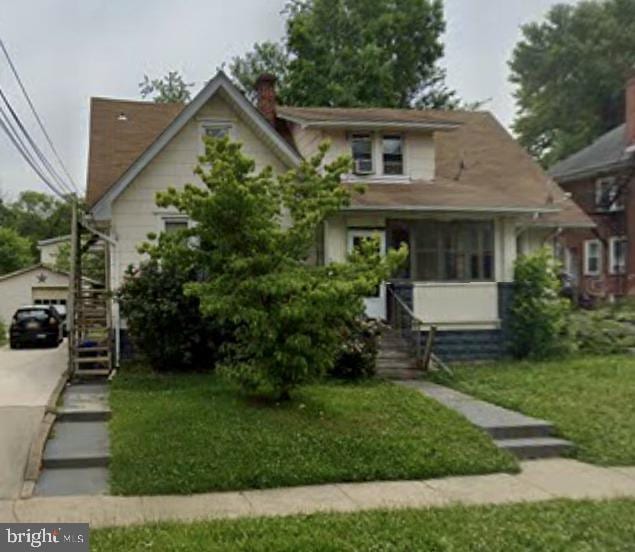 view of front of home with a garage, a front yard, and an outdoor structure